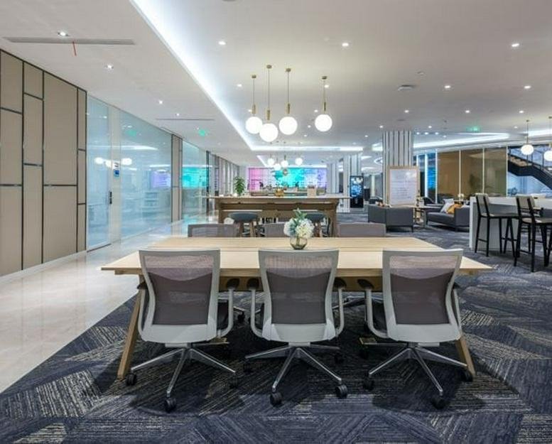 Spacious coworking lounge at Shenzhen Gemdale Centre with modern chairs and long wooden tables.