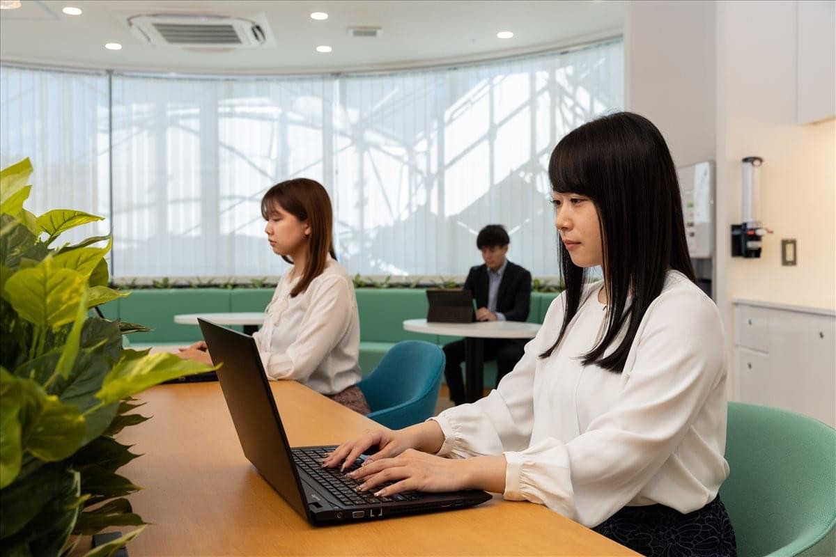 Clean, modern workspace at 140 Kajimachi, AOI Tower C Building, Shizuoka featuring wooden desks and plants.