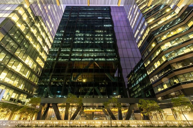 Dusk view of the modern glass facade of 141 St Georges Terrace in Perth.
