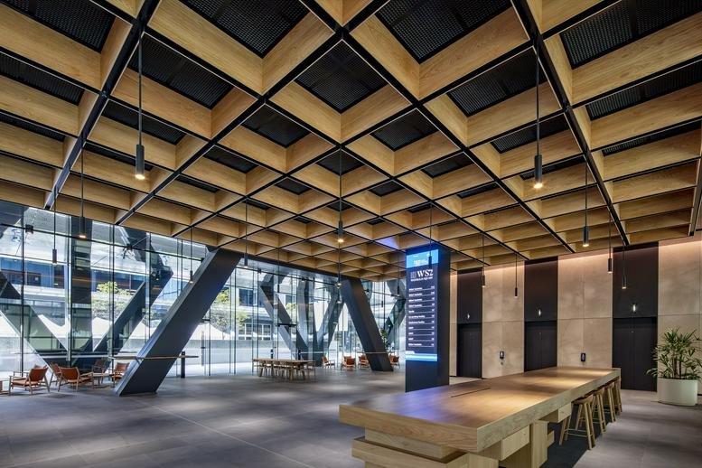 Grand lobby entrance with high timber-grid ceilings and warm architectural lighting.