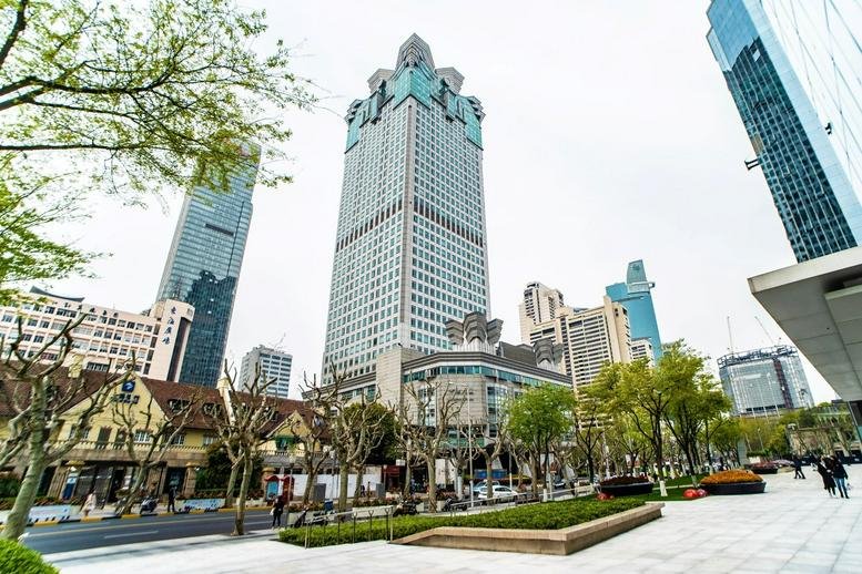 Exterior view of the towering United Plaza skyscraper surrounded by city trees.