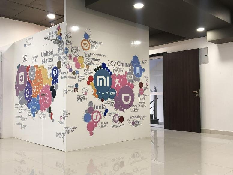 Spacious common area at 147 Mahaveer Nagar with a world map mural and polished tile floors.