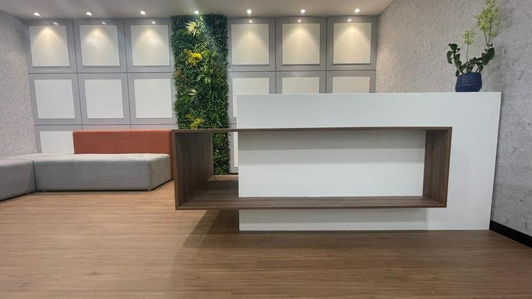 Modern reception desk at 14th Main Road, 1st Floor, Sector 7, Bangalore with wood accents and a green feature wall.