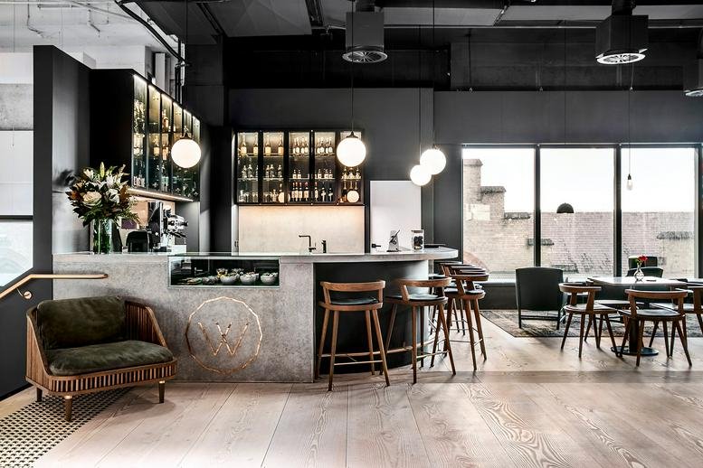 Spacious communal cafe and bar area with globe pendant lights at 151 Clarence Street, Barrack Place.
