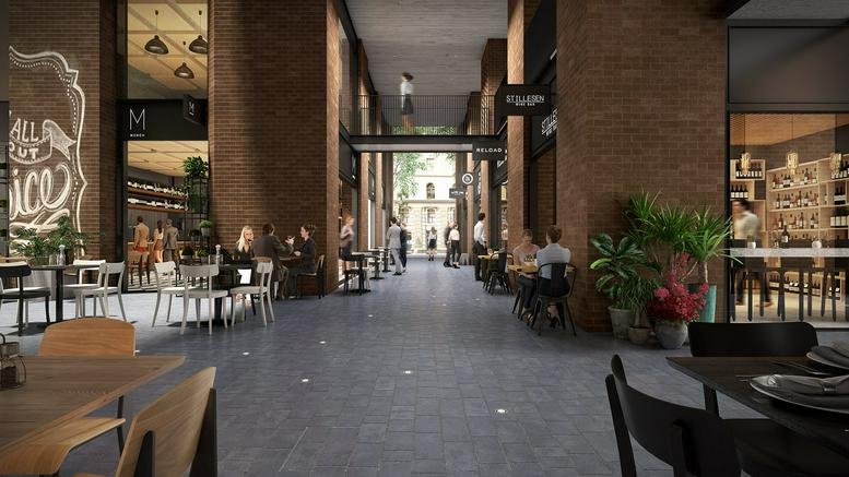 Industrial-style brick corridor with dining tables and plants.
