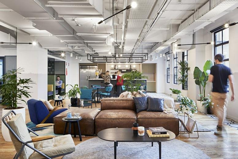 Spacious communal lounge at 152 Elizabeth Street, Melbourne CBD with brown leather sofas and indoor plants.