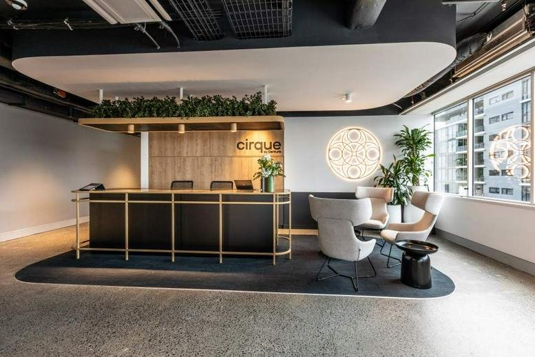 Reception area at 154 Melbourne Street, South Brisbane featuring a sleek desk and designer lounge chairs.