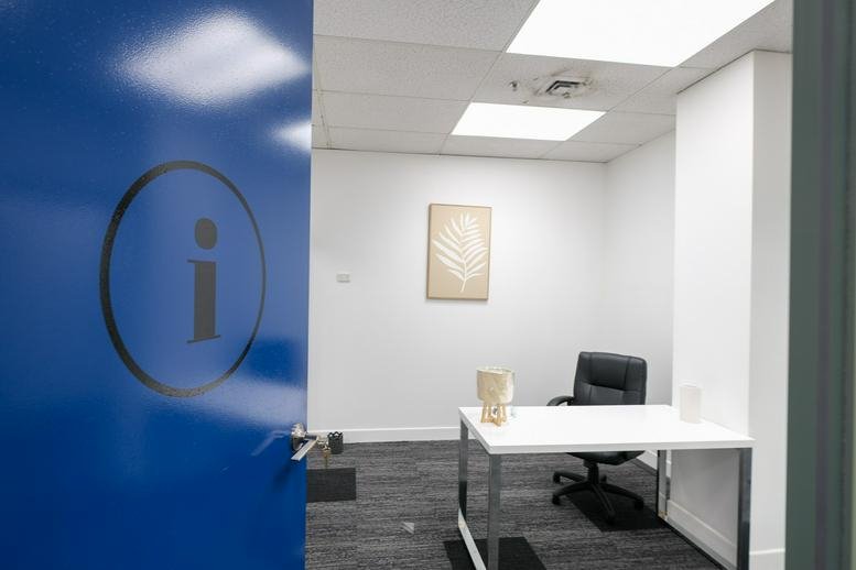 Professional private office at 161, London Circuit with white desk and blue door decal.