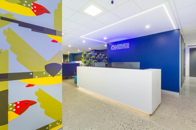 Reception area at 162 Grand Boulevard with a sleek white desk and blue feature wall.