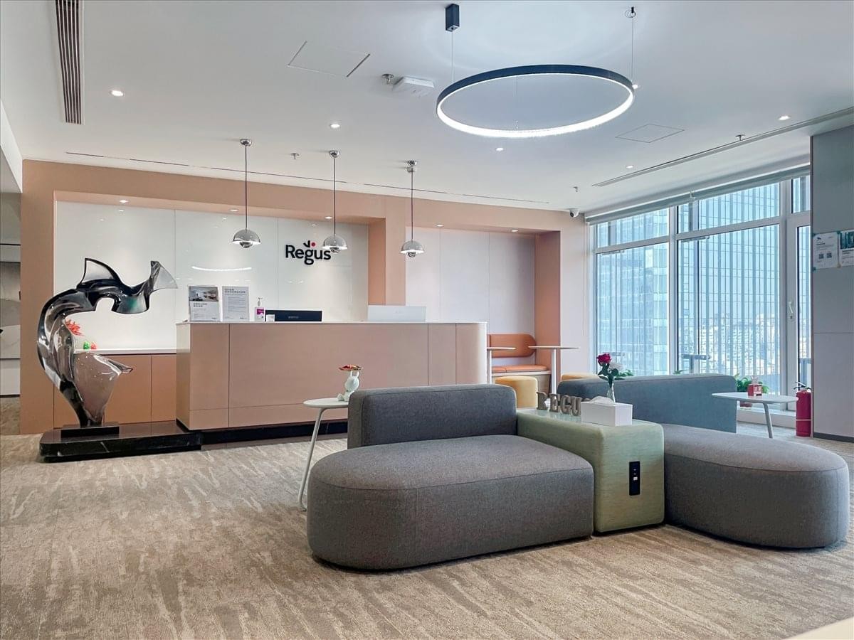 Modern lobby area at 167 Qingnian Street featuring a light wood reception desk and abstract sculpture.
