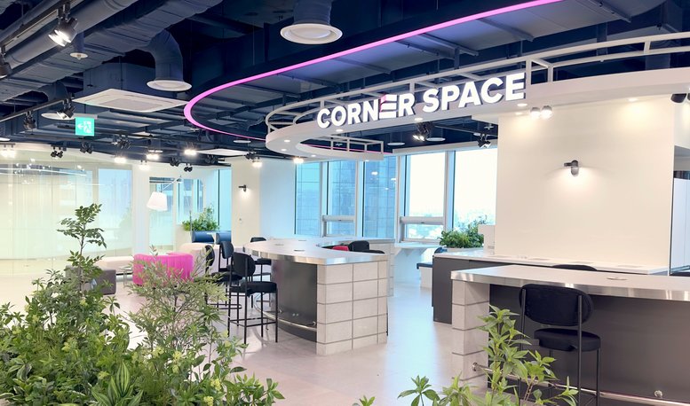 Spacious communal lounge at CornerSpace Yongsan, Seoul with modern seating, plants, and city views.