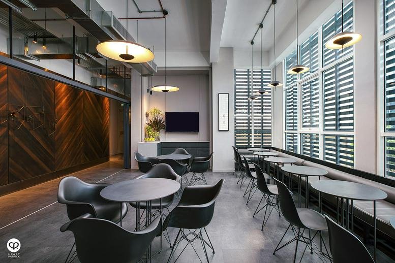 Spacious communal dining area at 17, Jalan Yap Ah Shak with round tables and designer chairs.