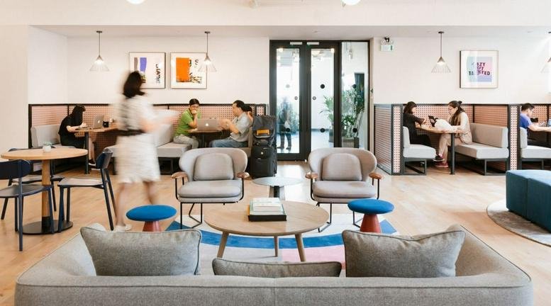 Spacious communal lounge at 33 Zhongshan 5th Road with modern armchairs, a coffee table, and booth seating.