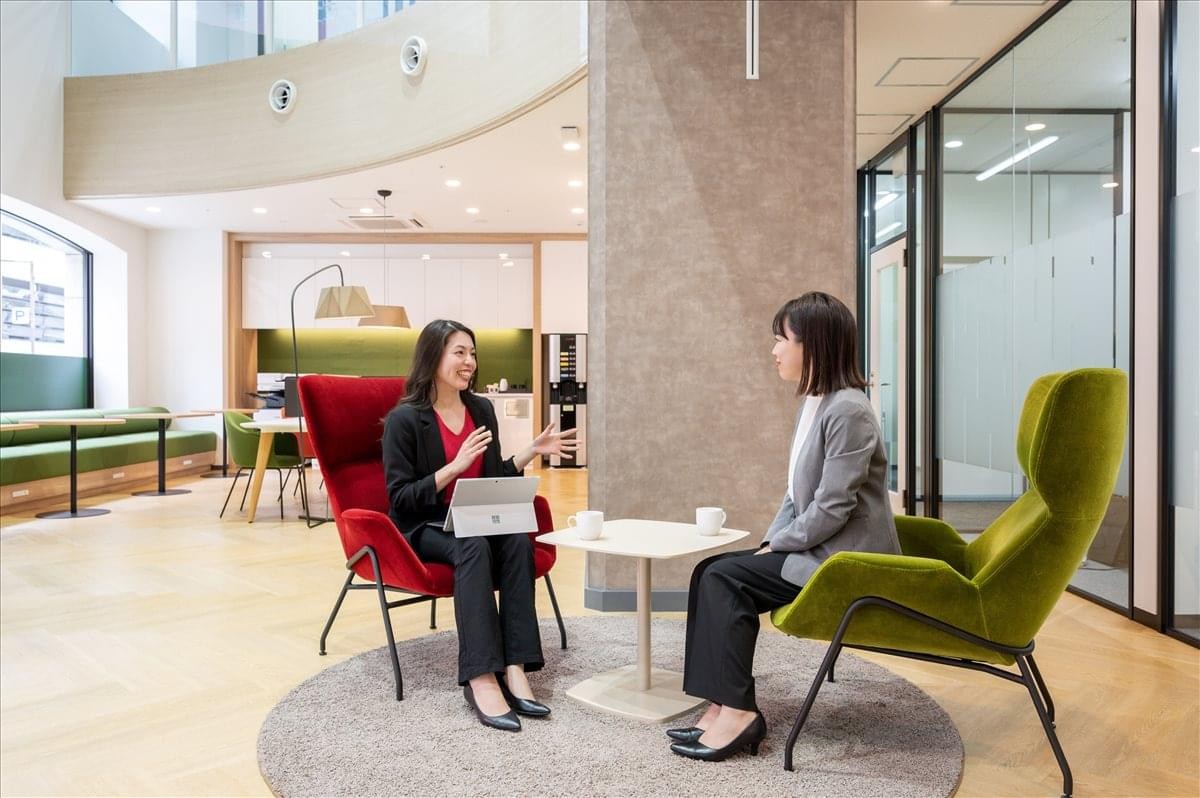 Bright, modern communal lounge at Hakata Prestige with comfortable seating and professionals chatting.