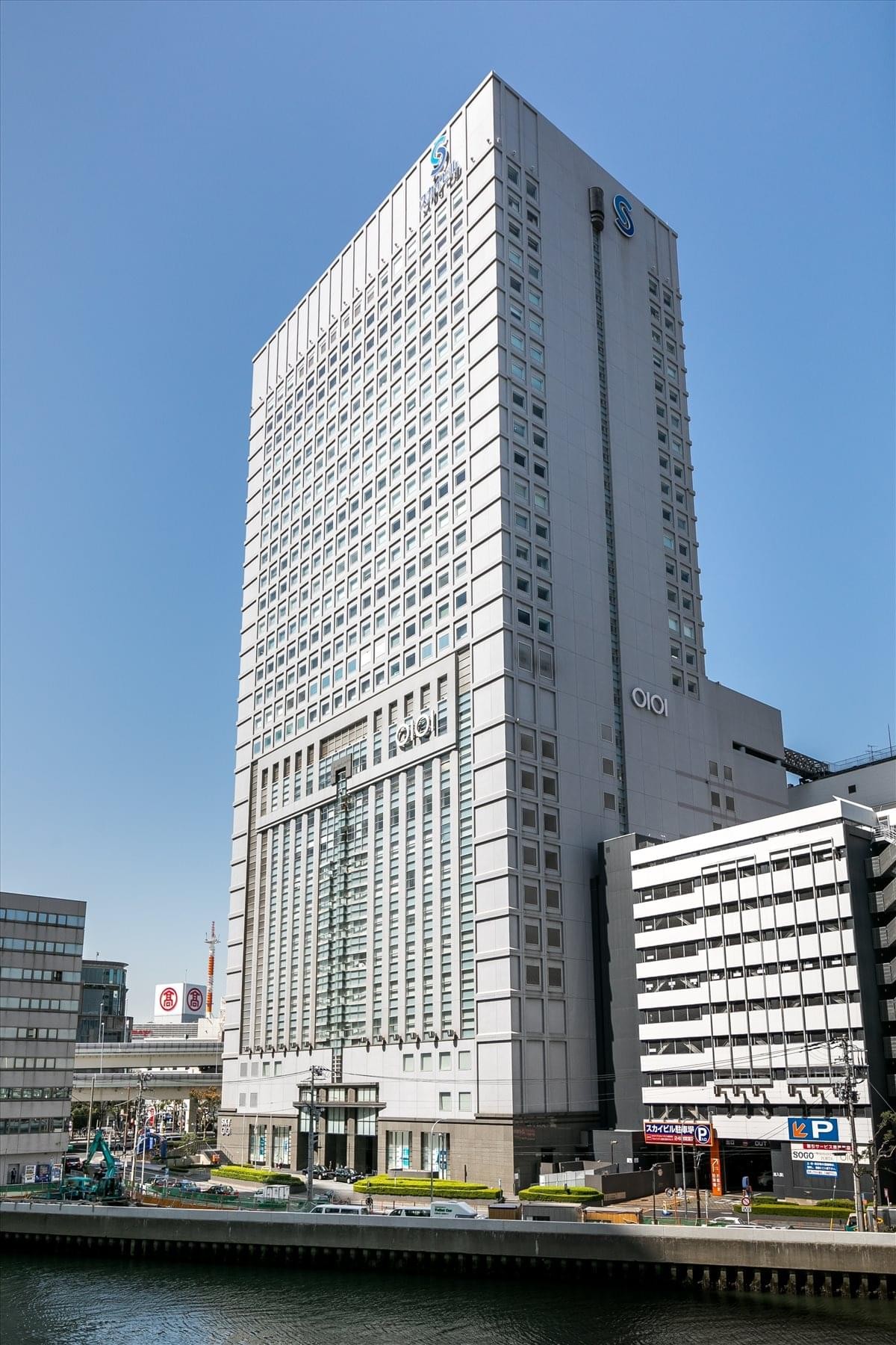 Exterior view of the tall, multi-story Yokohama Sky Building against a clear blue sky.