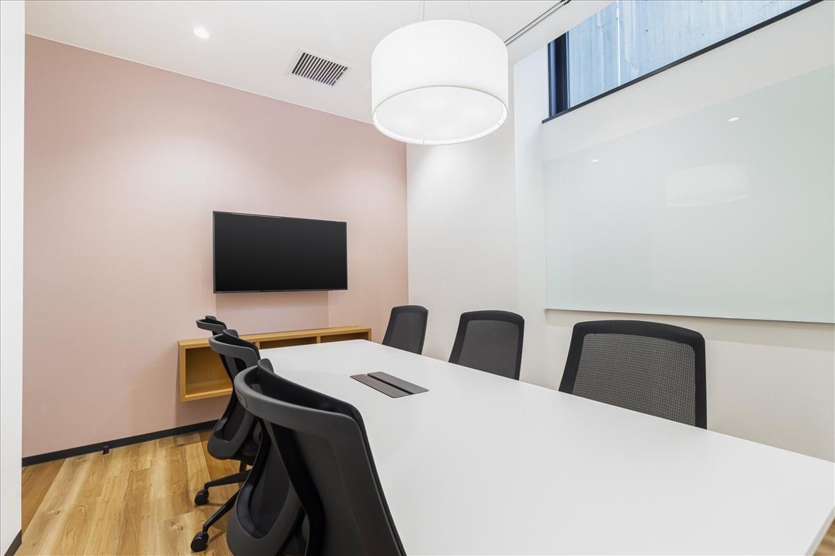 Meeting room at 2-9 Saiwaicho, Daiwa Roynet Hotel, Yamagata with a pink feature wall and large white pendant light.