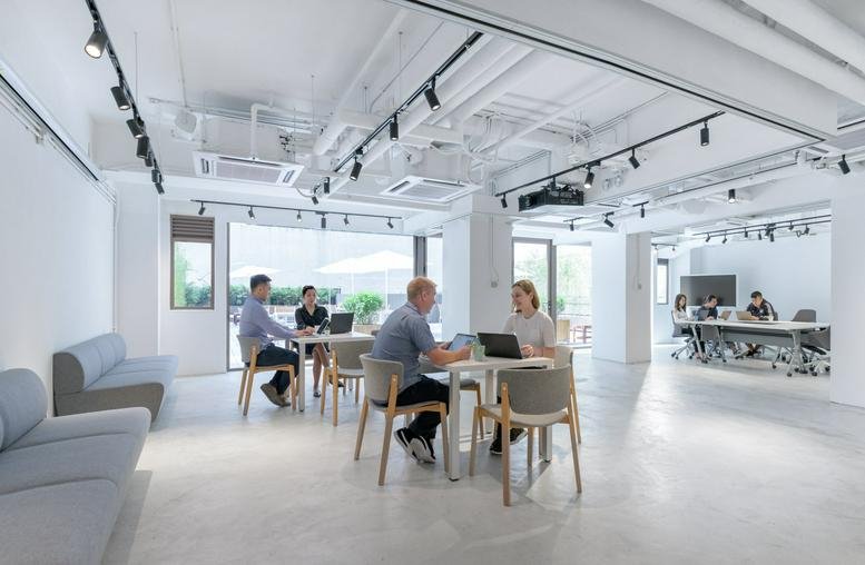 Spacious open-plan common area at Strand 50 with natural light and multiple seating arrangements.