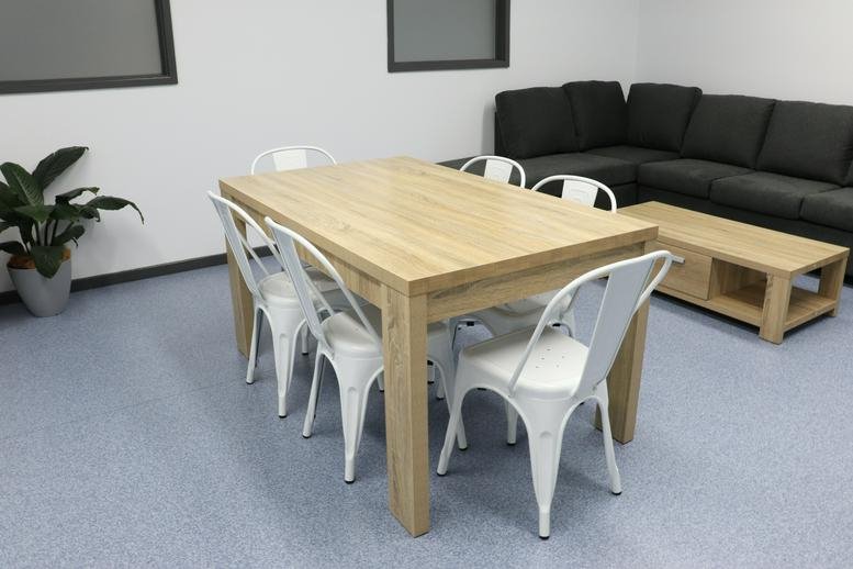 Spacious communal dining area at 2 Portside Crescent, Newcastle featuring a light wood table and white chairs.