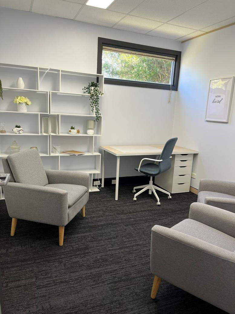 Quiet private office suite at 2 Portside Crescent, Newcastle featuring a desk, shelving, and comfortable armchairs.