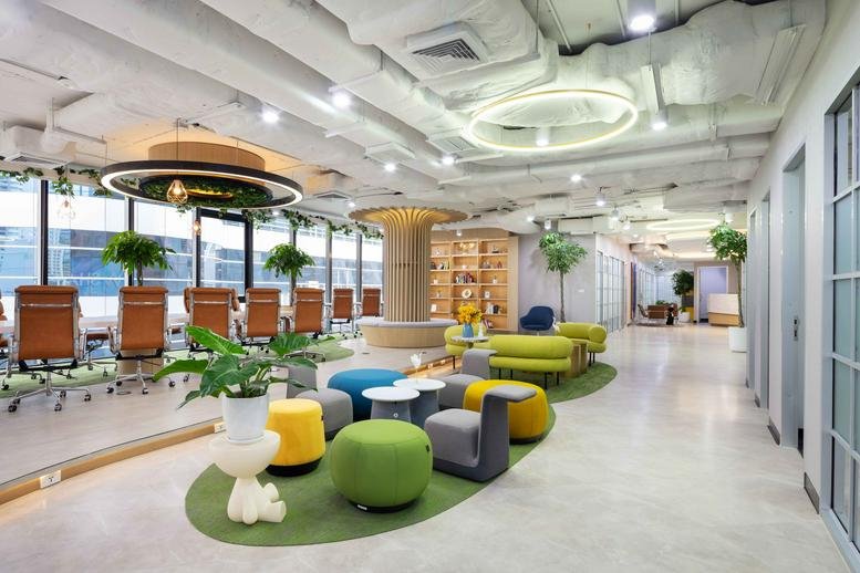 Spacious coworking lounge at Quant Building with colourful stools and natural light.