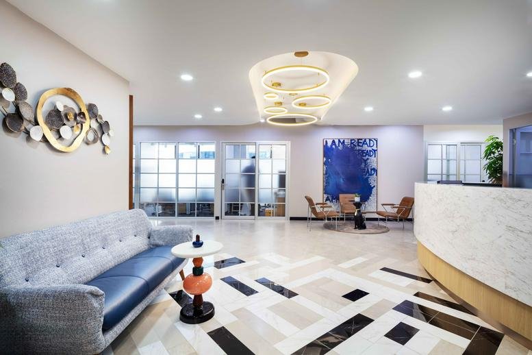 Grand lobby at Quant Building with a marble reception desk and designer ring lighting.