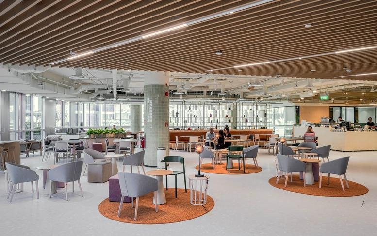 Spacious communal lounge at Paya Lebar Quarter 3 featuring circular rugs and designer seating.