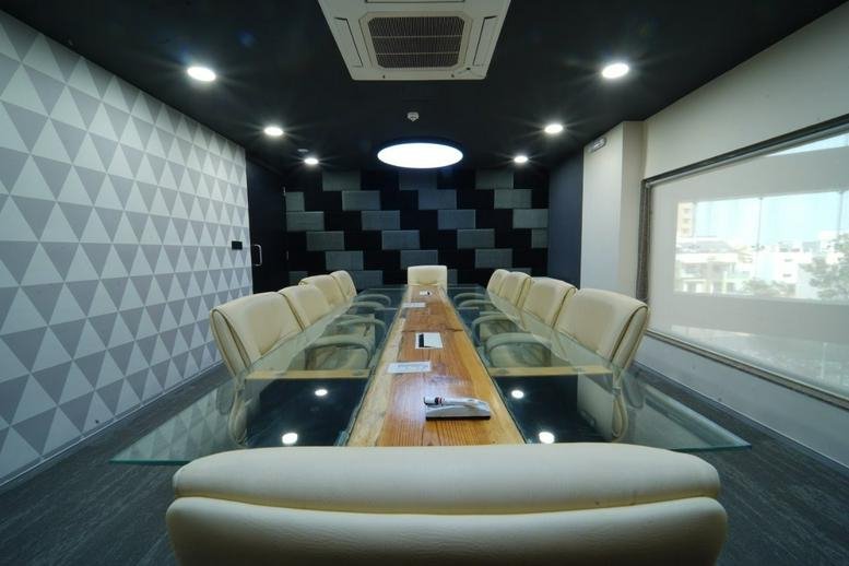 Sleek modern boardroom at The Capital with a glass-topped table and textured feature wall.