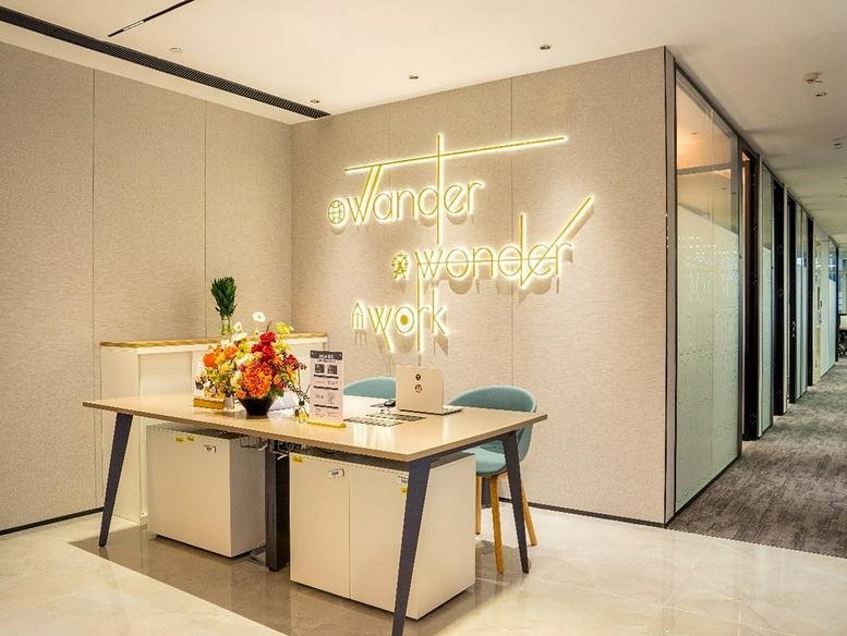 Bright reception desk at 20F GT Land G Tower with floral arrangement and illuminated wall signage.
