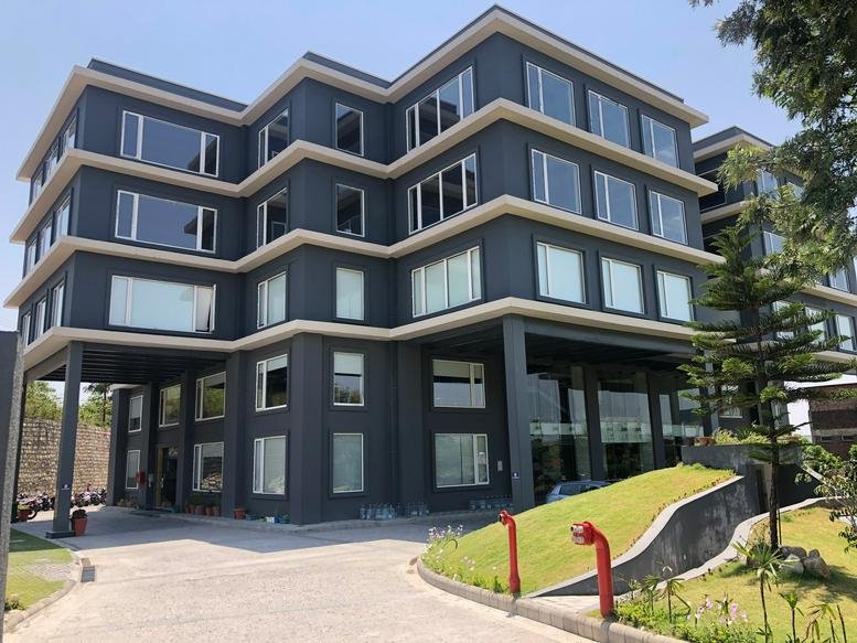 Exterior view of the multi-story dark gray building at 21, IT Park, Sahastradhara Road, Dehradun.