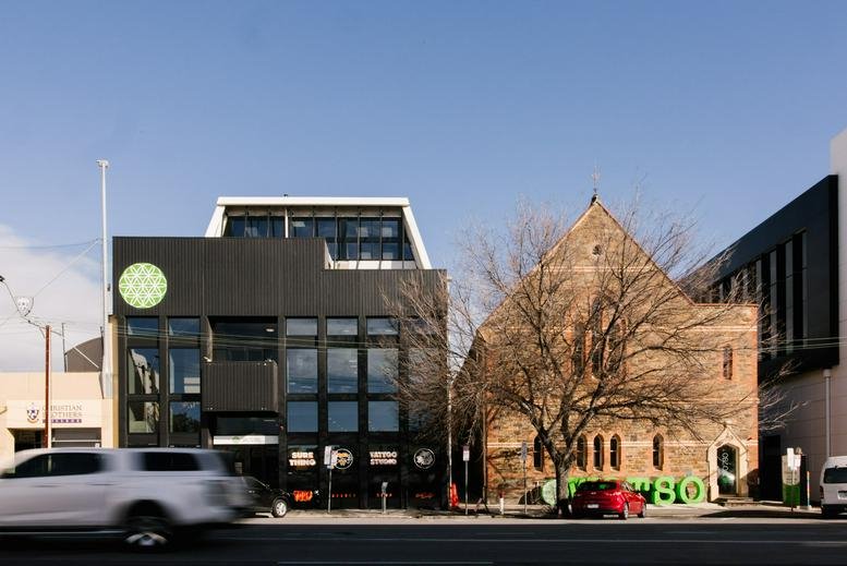 Street view of the 217-219 Flinders Street, Ground Floor, Adelaide building and adjacent stone church.