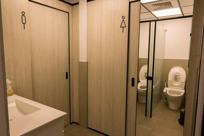 Clean and modern gender-neutral restrooms with wooden doors.