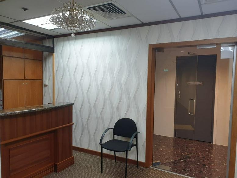 Reception entrance featuring a glass door and a small crystal chandelier.