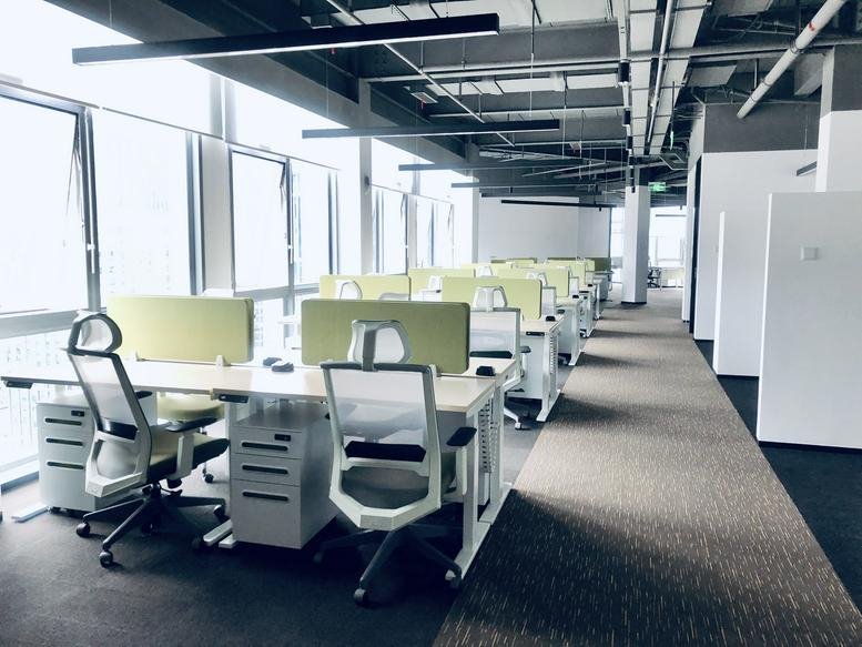 Bright, open-plan workspace at Guangzhou South Media Centre featuring rows of desks and large windows.