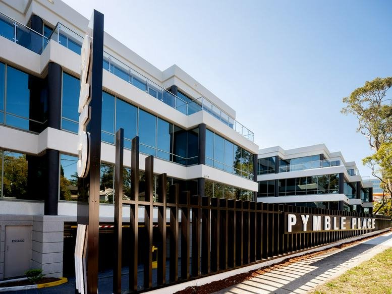Modern multi-story exterior facade of Pymble Place with glass windows and black architectural pillars.