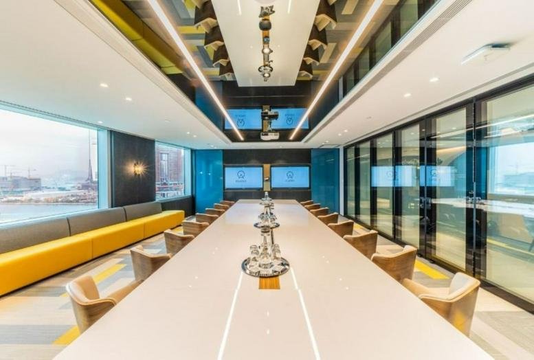 Large modern boardroom at 25F Guangdong Development Center with a long white table and yellow bench seating.