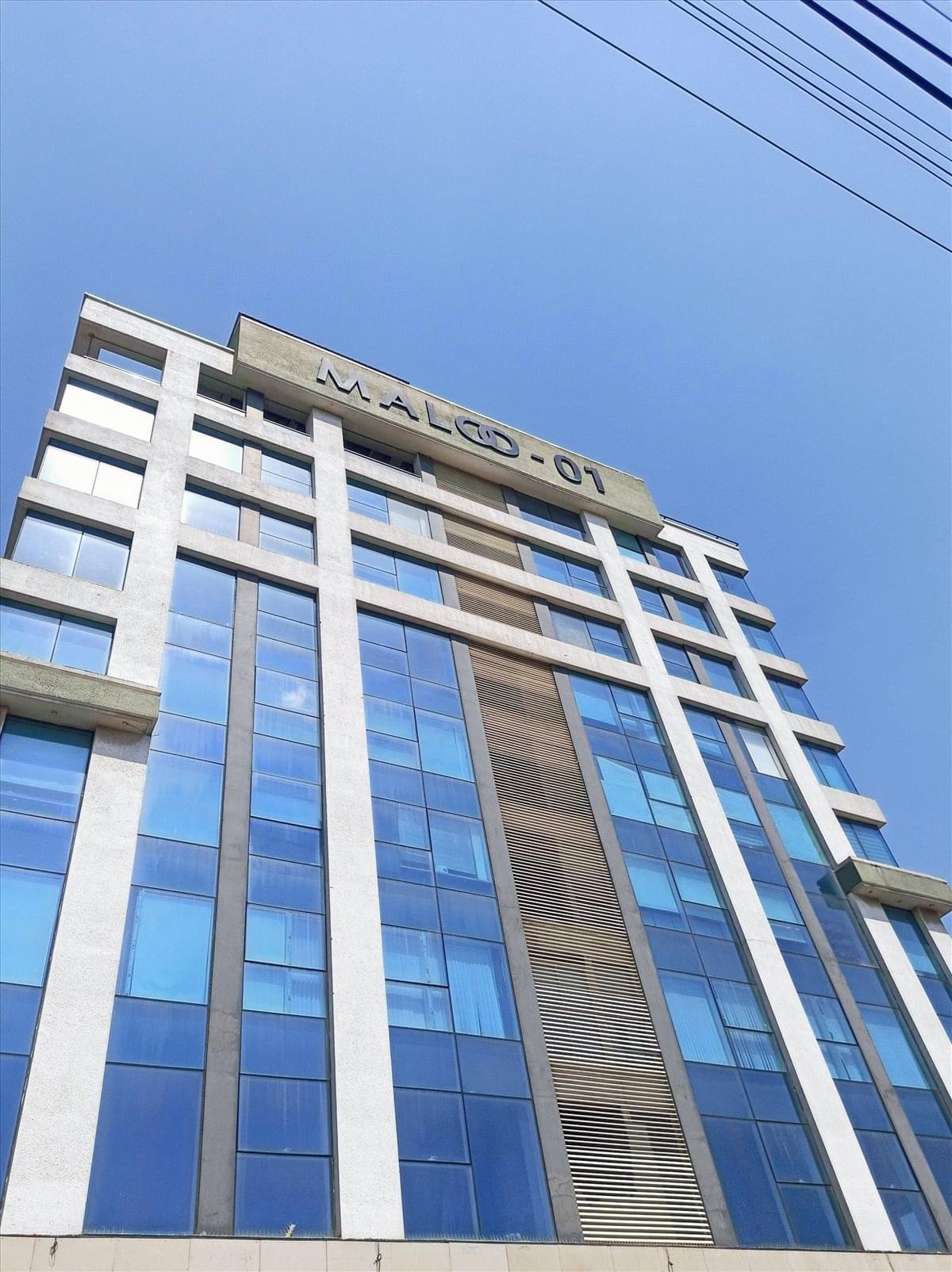Exterior view of the modern glass and concrete facade of Maloo 1 in Indore.