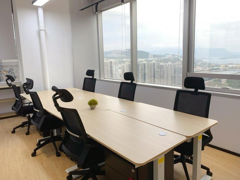 Internal office suite at Delta House featuring sleek wooden desks and views of the surrounding hills.