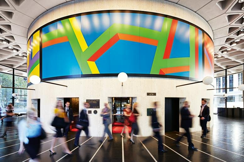 Circular lobby area featuring a vibrant geometric mural and high ceilings.