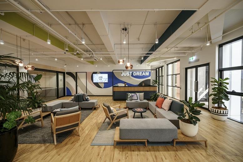 Spacious reception and lounge area at 276 Flinders Street, Melbourne, Victoria with wooden floors and plants.