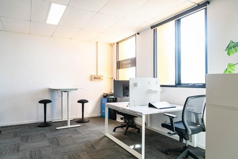 Spacious sunlit office at 283 Old Geelong Road with standing desks and ergonomic chairs.