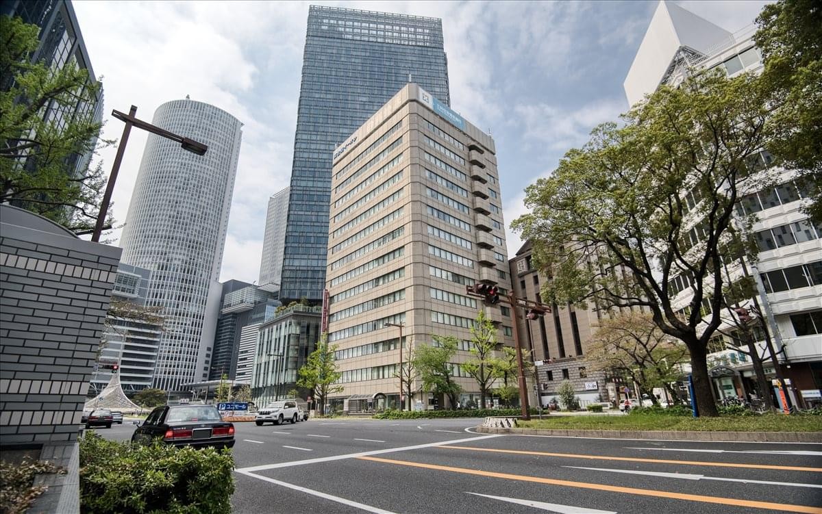 Exterior view of the KDX Nagoya Ekimae Building in a bustling city center surrounded by skyscrapers.