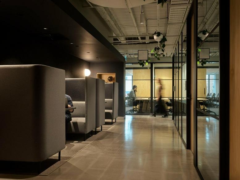 Quiet corridor featuring private high-back seating pods for focused work.