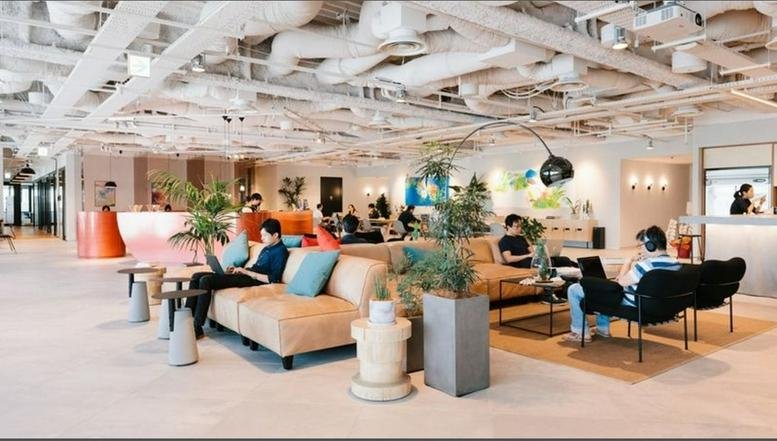Spacious open-plan workspace with a lounge area and modern decor.