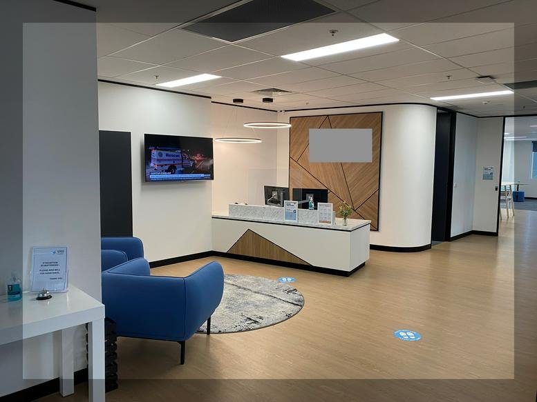 Modern lobby area with a sleek white reception desk and blue armchairs at 30 Pearson Street, Level 3, Newcastle.