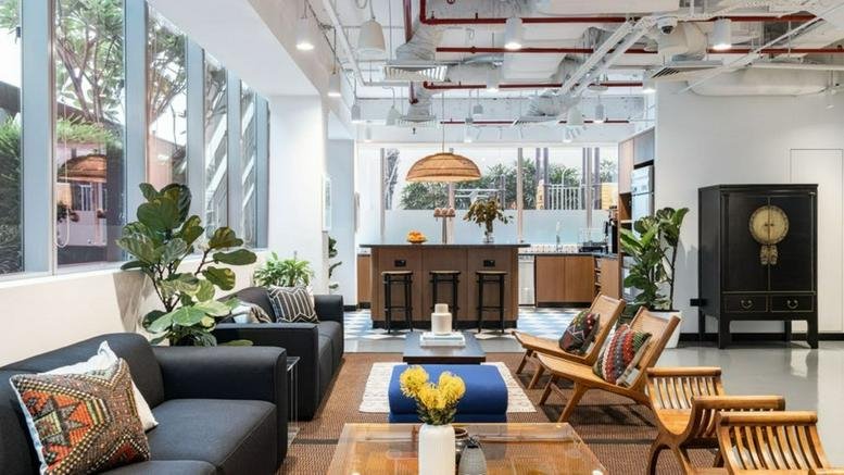 Modern lounge area featuring comfortable sofas, wooden armchairs, and a stylish bar counter.