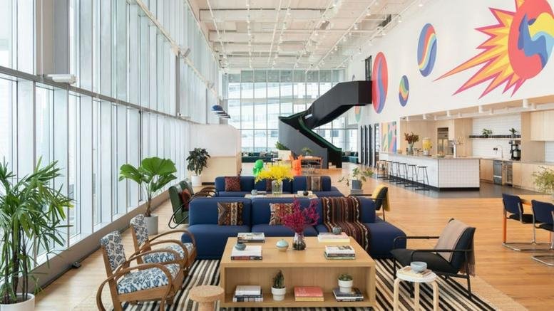 Spacious, sun-lit lounge at 30 Raffles Place with a striking black spiral staircase and colorful wall mural.