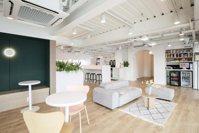 Bright, open-plan lounge at 303 Gonghang-daero with grey sofas, wooden floors, and a coffee station.