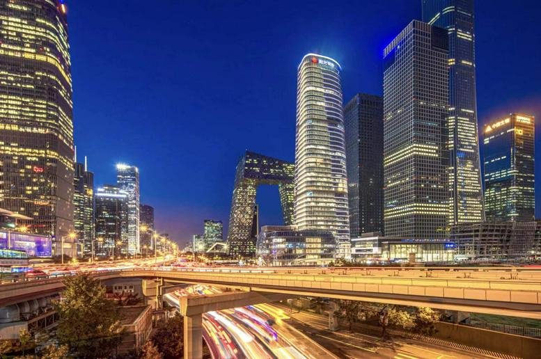 Evening view of the illuminated Sunshine Financial Center skyscraper within the Beijing city skyline.