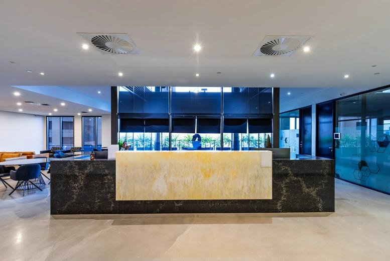 Modern stone reception desk at 333 Collins Street, Level 14, featuring backlit marble and dark accents.