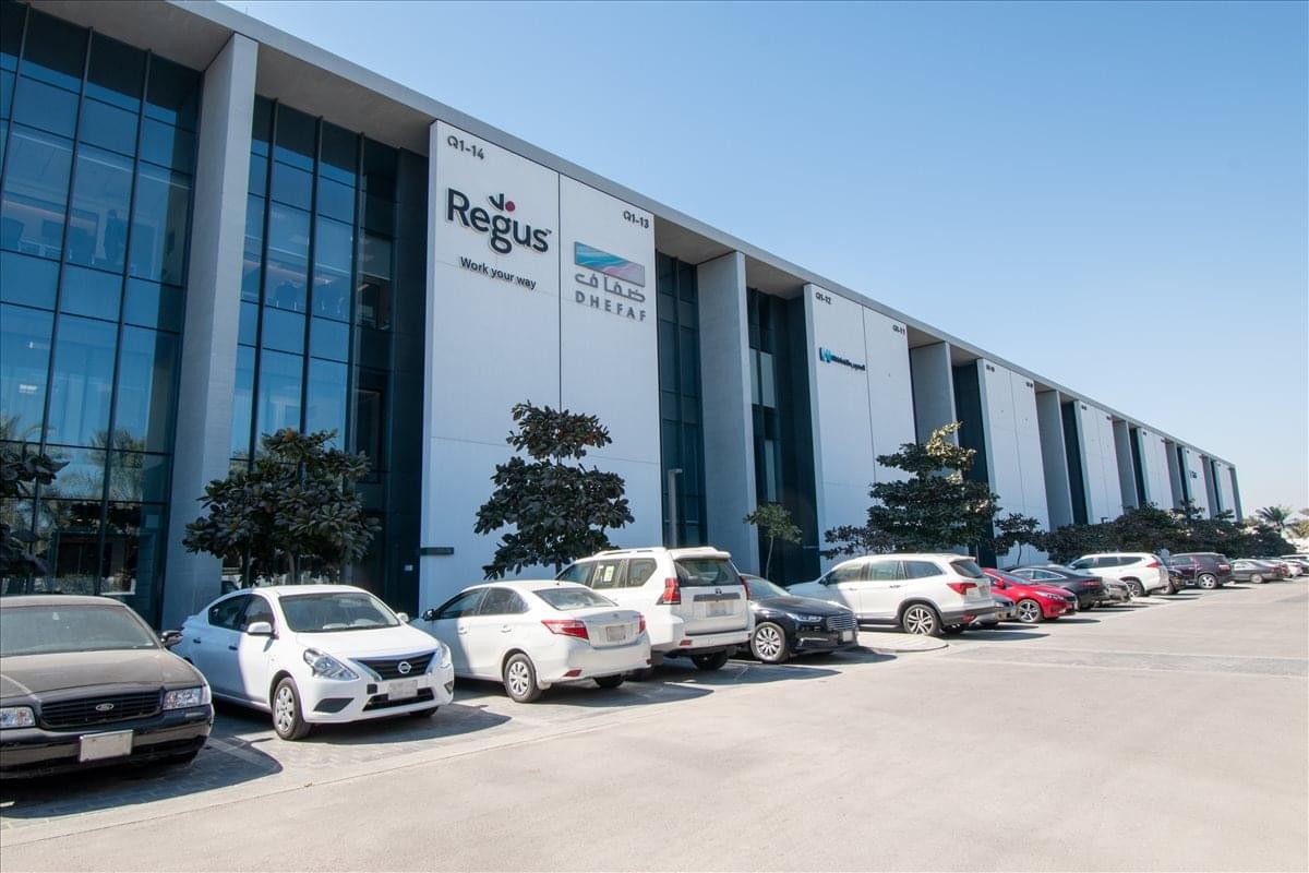 Modern exterior of the 3640 King Faisal Road office building with parking and a glass facade.
